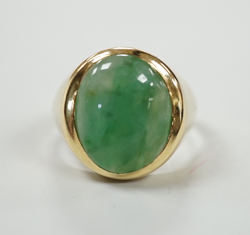 A modern 18ct gold and cabochon oval jade set ring, size P, gross weight 7.1 grams.